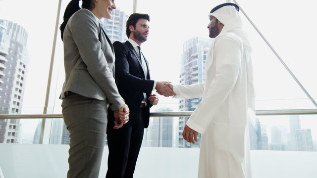 handshake Middle East male female business team meeting stocks shares trading 