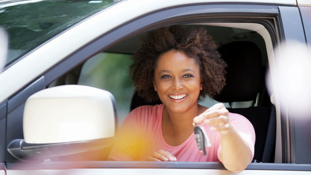 Portrait of happy confident African American girl driving new car