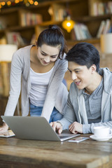 Young couple using laptop in cafe