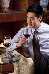 Young businessman enjoying wine in hotel