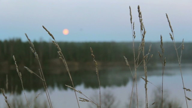 full moon over foggy river in early morning