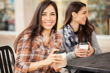 Cute girl having coffee with some friends