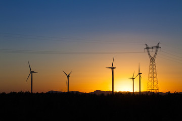Electricity pylon and windmills in Inner Mongolia province, China