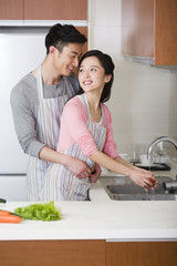 Happy young couple preparing meal