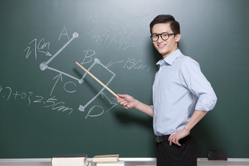 Confident Male teacher giving lessons in classroom
