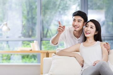 Young couple looking up in living room