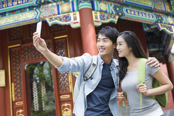 Fototapeta na wymiar Young couple taking self portrait with smart phone