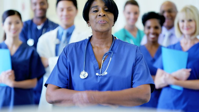 Portrait of confident African American female nurse wearing scrubs in hospital
