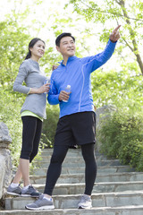 Happy mature couple holding bottled water after exercising