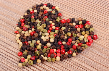 Heart of fresh colored pepper on wooden background