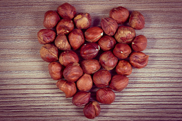 Vintage photo, Heart of brown hazelnut on wooden table