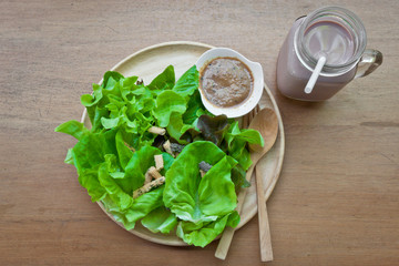 Green delicious salad and a glass of chocolate milk