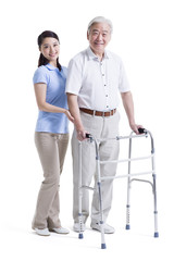 Female nursing assistant helping senior man with walking frame