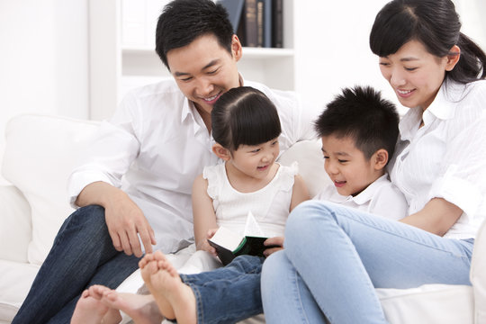 Happy family reading book in sofa