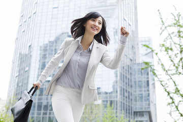 Running businesswoman with briefcase in hand