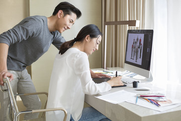 Young couple designing clothing together