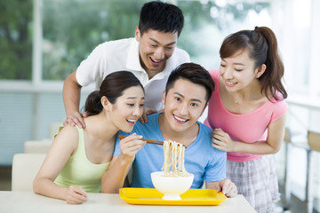 Young adults having noodles in restaurant