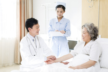 Doctor taking pulse of patient in hospital