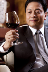 Mature businessman enjoying wine in a luxurious room