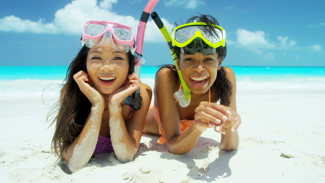 Young multi ethnic girlfriends in swimwear going snorkeling