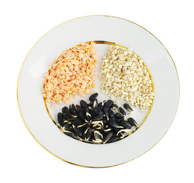 sprouts of lentil, buckwheat and sunflower seeds on plate, top view, on white isolated 