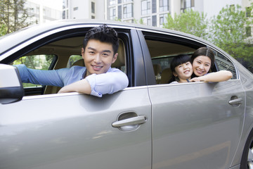 Happy young family in a car
