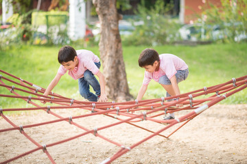 Little boy climbing on the rope at playground