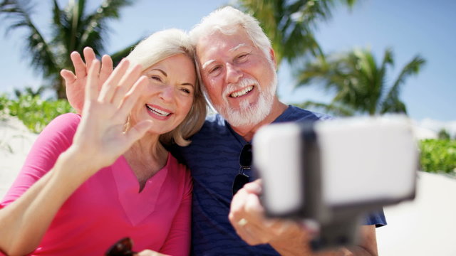 Mature Caucasian couple on Caribbean beach taking a selfie 