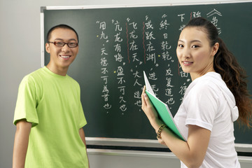 Man And Teacher Standing By The Blackboard
