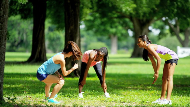 Young active multi ethnic girls doing fitness activity in park