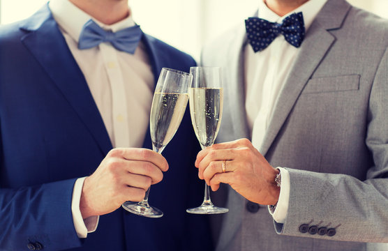 close up of male gay couple with champagne glasses