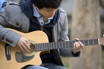 Close up of young boy playing guitar 