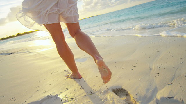 Caucasian female walking barefoot on the beach 