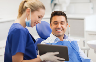 female dentist with tablet pc and male patient