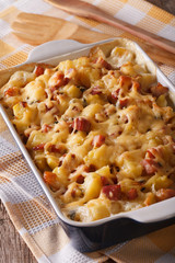 tartiflette: baked potatoes with bacon and cheese close up, vertical
