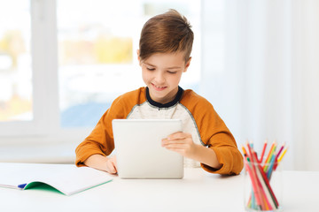 smiling boy with tablet pc and notebook at home