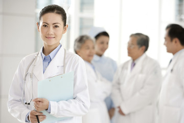 Female Doctor in Foreground with Doctors and Nurse in Background