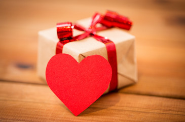 close up of gift box and heart shaped note on wood