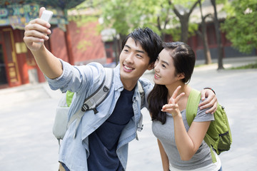Naklejka premium Young couple taking self portrait with smart phone