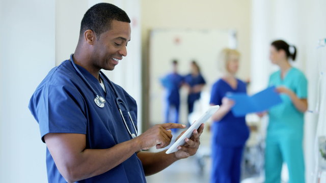Young African American male doctor working on tablet technology in hospital