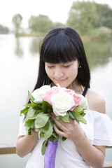 Young woman holding bouquet outdoors