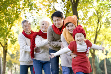 Three Generation Family Playing in a Park in Autumn