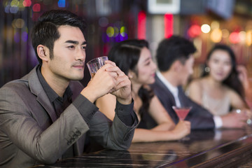 Young man drinking alcohol in bar