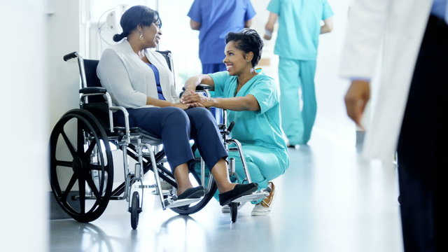 African American female nurse and disabled patient consult in medical centre 
