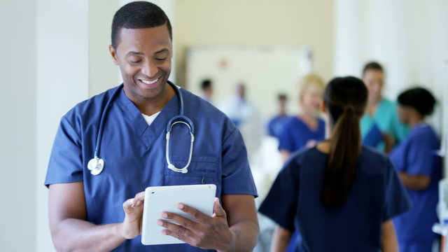 Portrait of young African American male staff working on technology in hospital