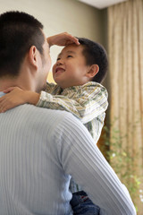 Fototapeta premium Boy Measuring His Height Against His Father