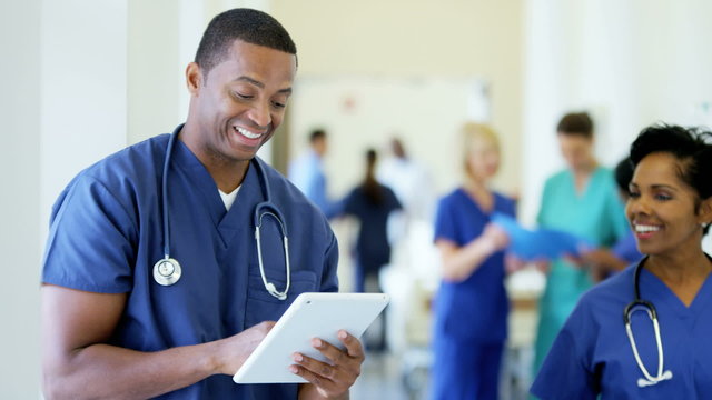 Portrait of African American male nurse working on tablet technology in hospital