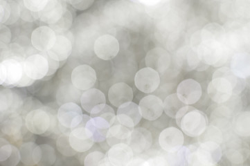 Light blurred background with white bokeh lights on it. Festive holiday theme with copyspace