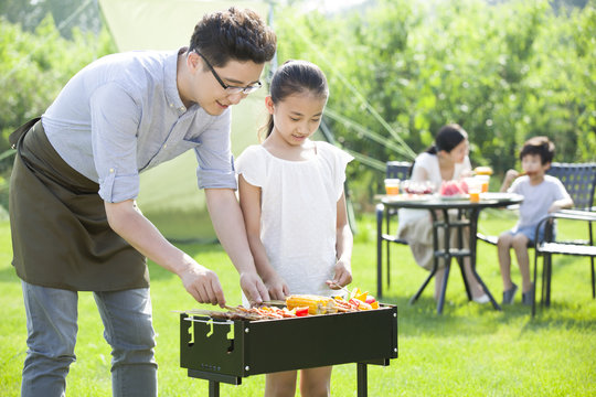 Young family barbecuing outdoors