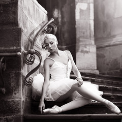 Obraz premium Graceful beauty. Monochrome shot of a young ballerina posing on stone stairs